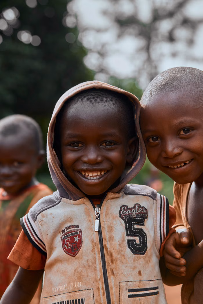 Children from the community smiling together outdoors